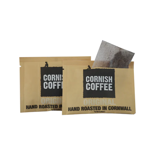 Two cornish coffee packages with a single coffee filter on a white background