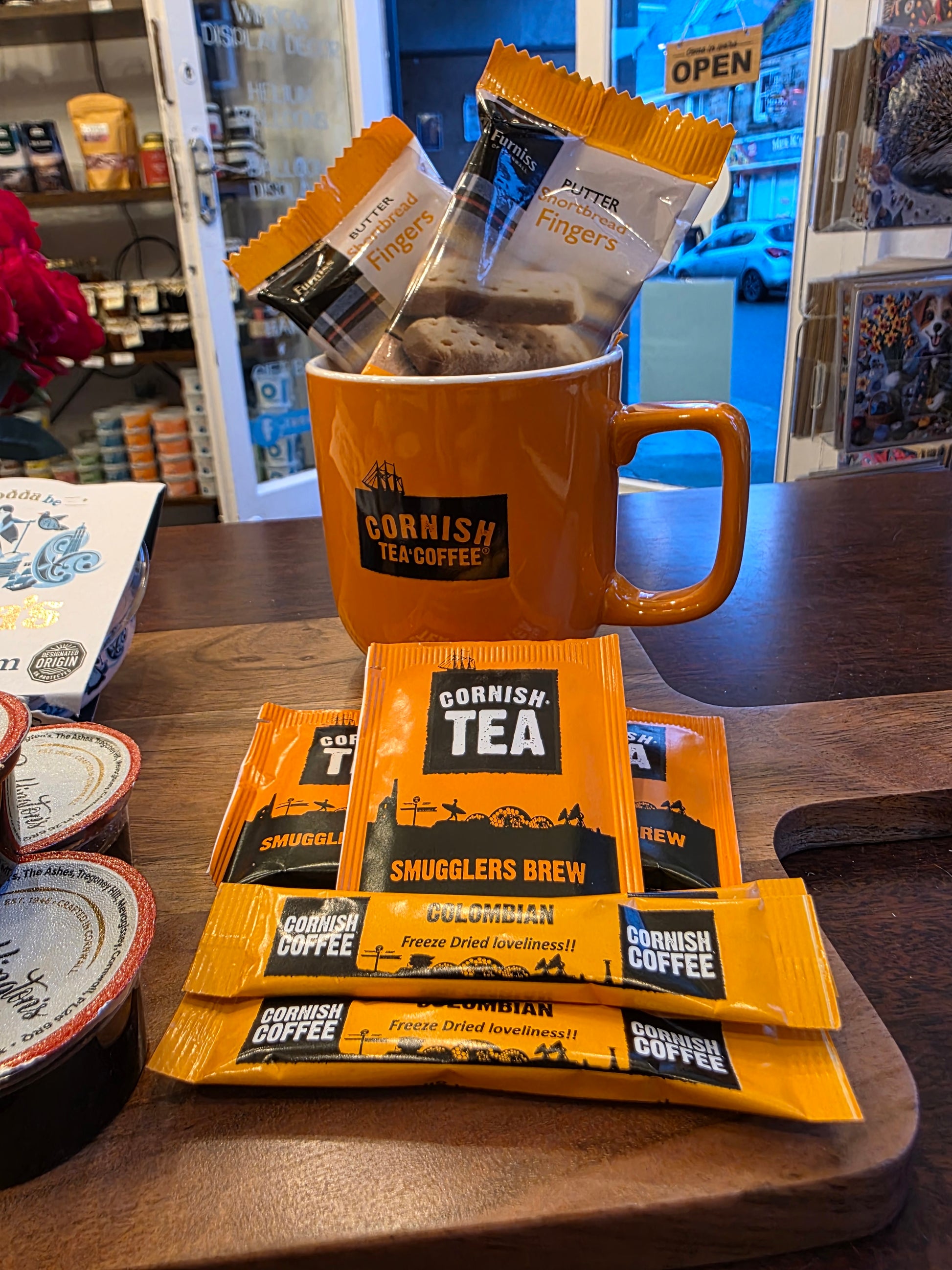 Cornish Coffee and Tea packages on a wooden surface with a store interior background.