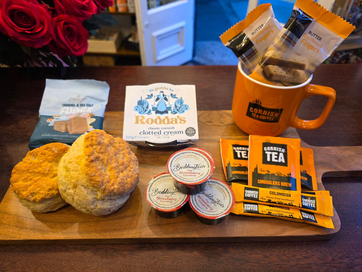 Assorted food and tea products on a wooden tray with a blurred background