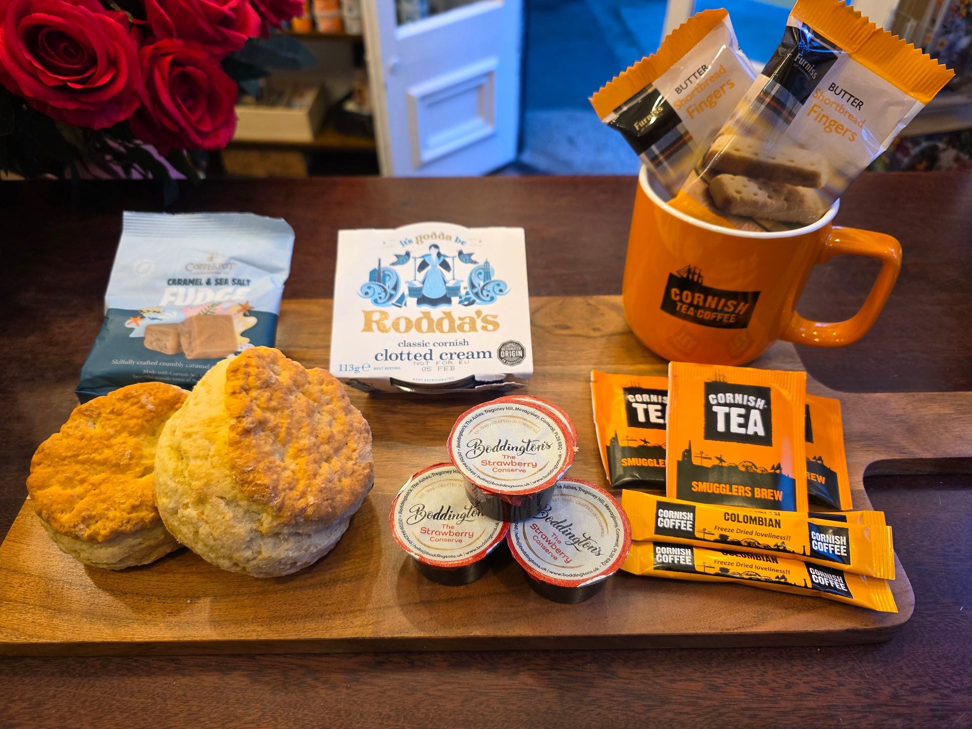 Assorted food and tea products on a wooden tray with a blurred background