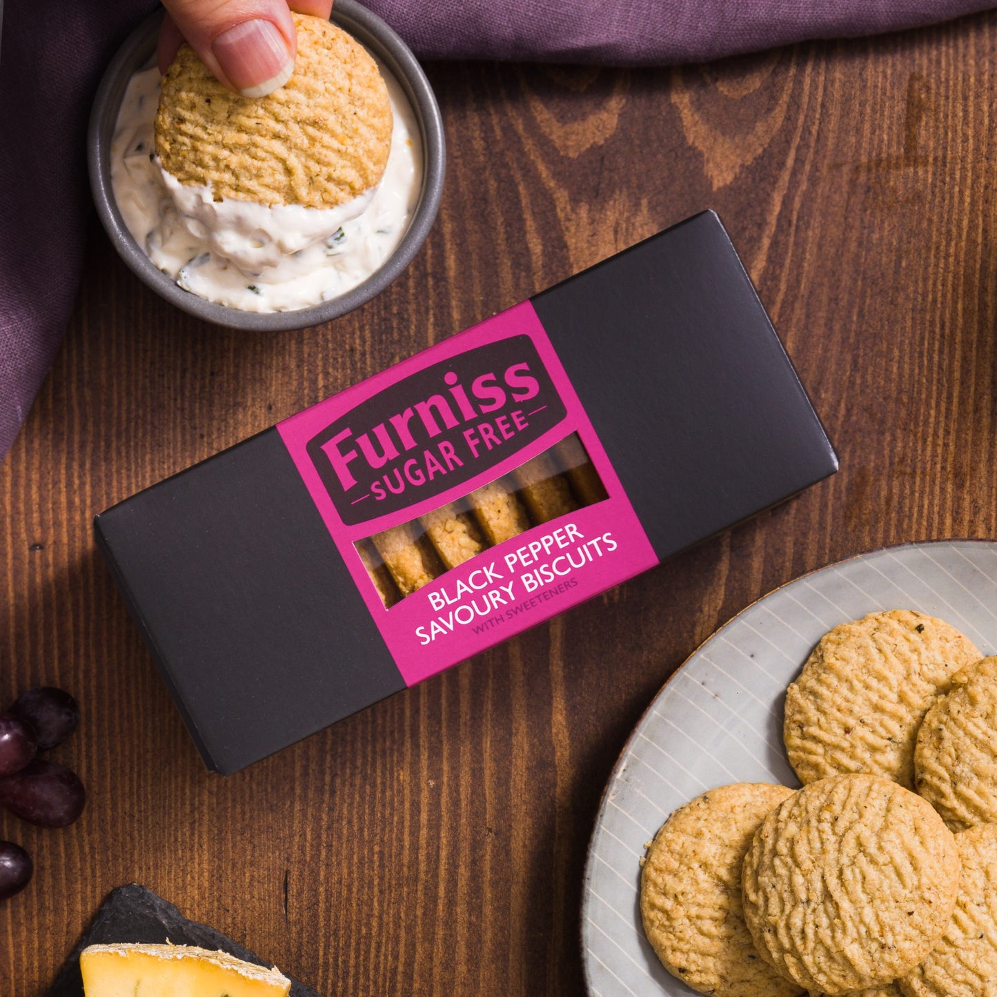 Furniss sugar-free black pepper savoury biscuits with packaging on a wooden table.